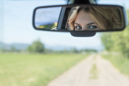 Person looking in a rearview mirror