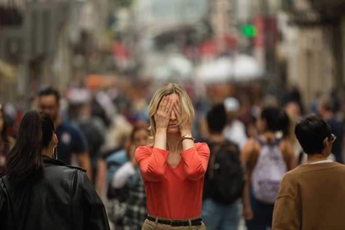 Woman covers her face in a crowd