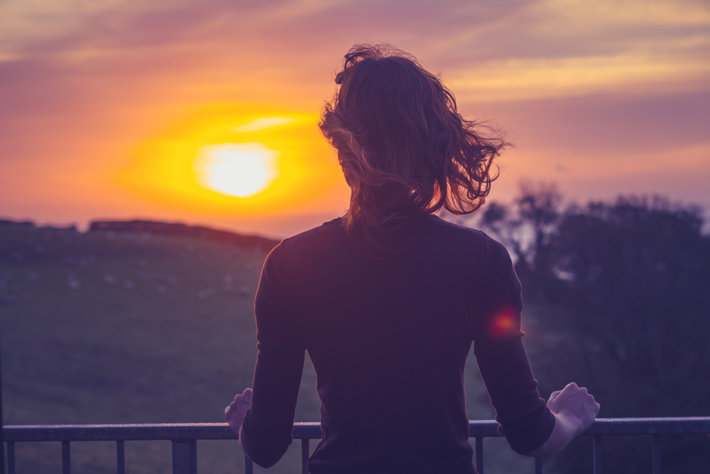 Woman free from alcohol addiction watching sunset.