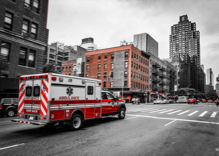 Ambulance rushing on a gray street 